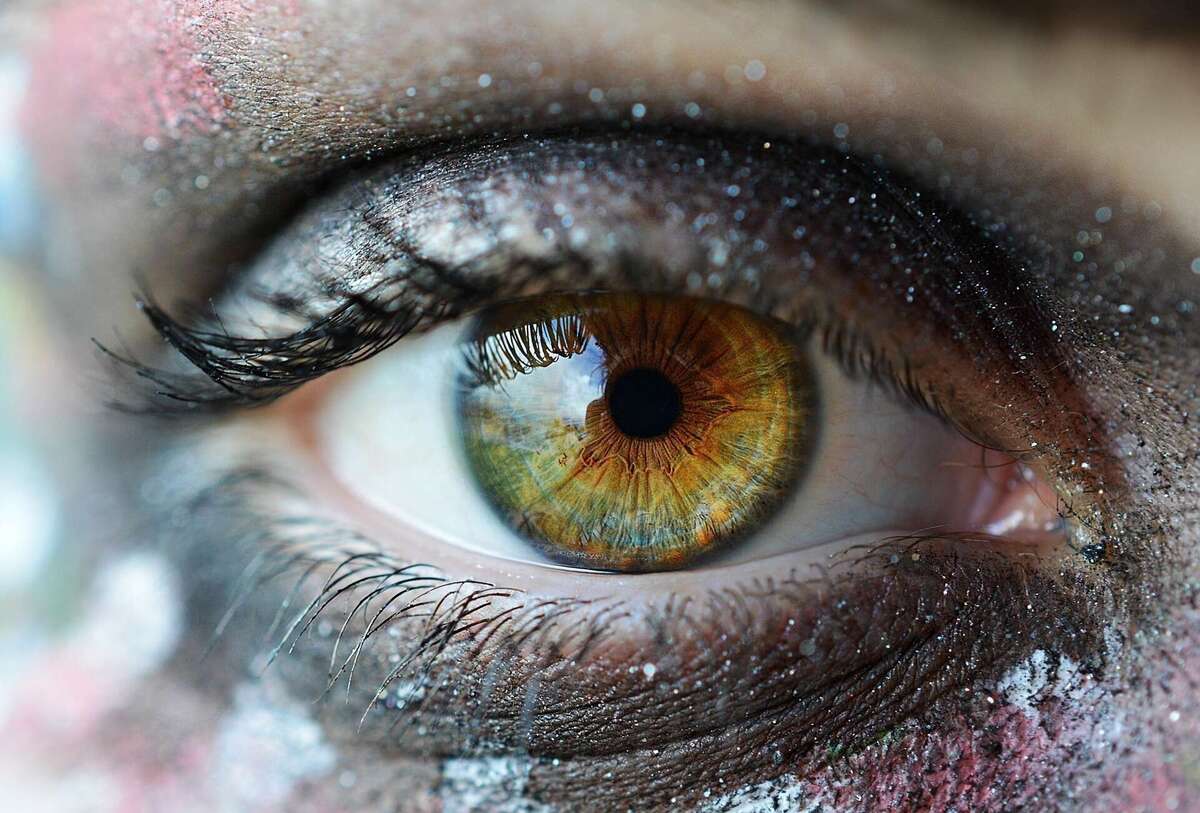 Gros plan d'un iris noisette dont on distingue les fibres rayonnant autour de la pupille