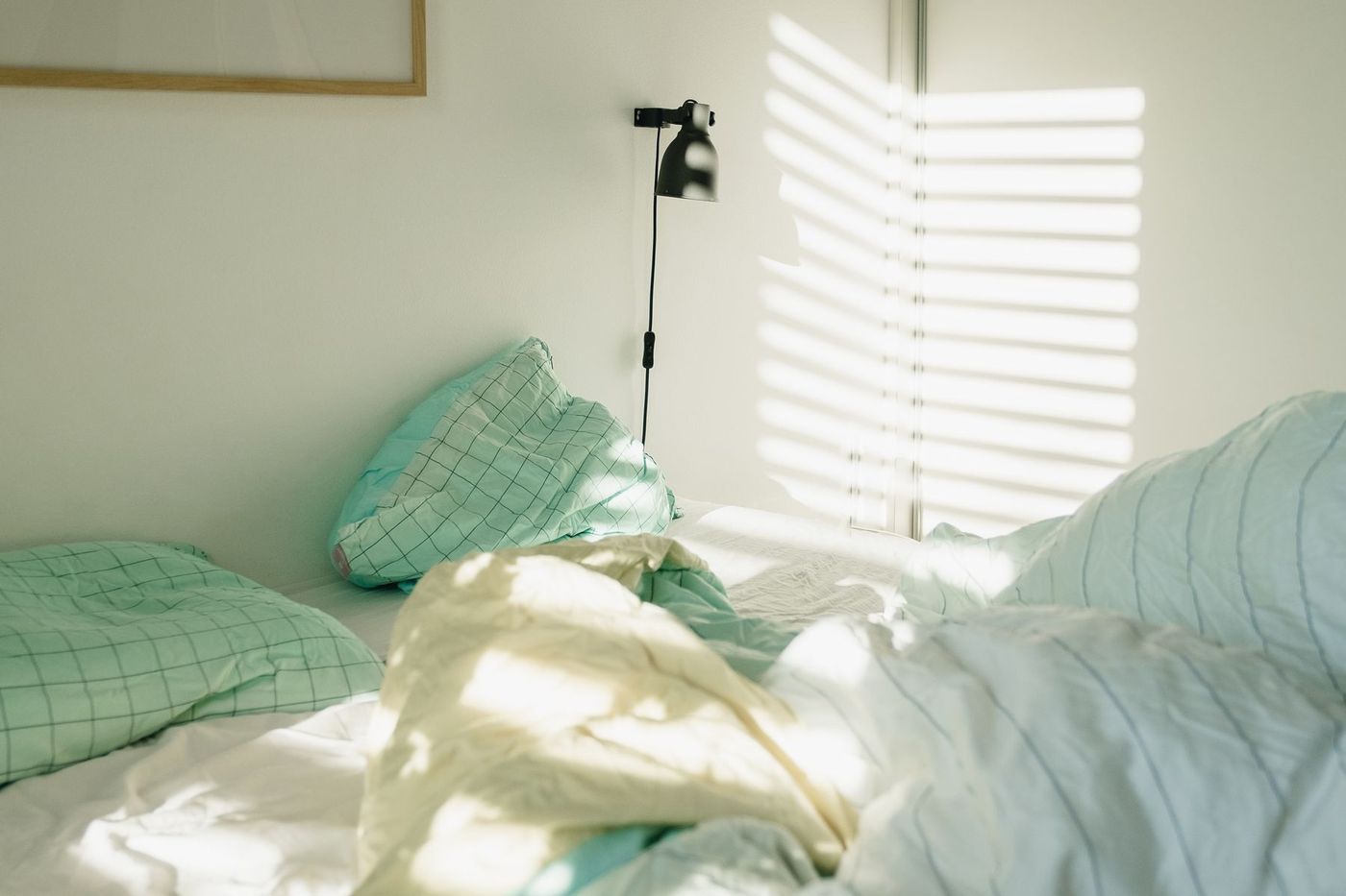 Une chambre claire au petit matin, la lumière filtrant à travers un store